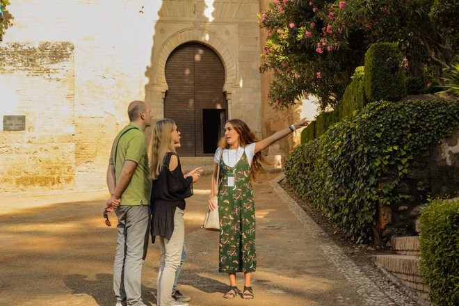 Free walking tour guide showing something to a couple of travelers in Andalucia with GuruWalk.