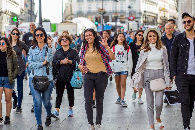 Guía de free tour de GuruWalk en Madrid camina en una calle con su grupo de viajeros.